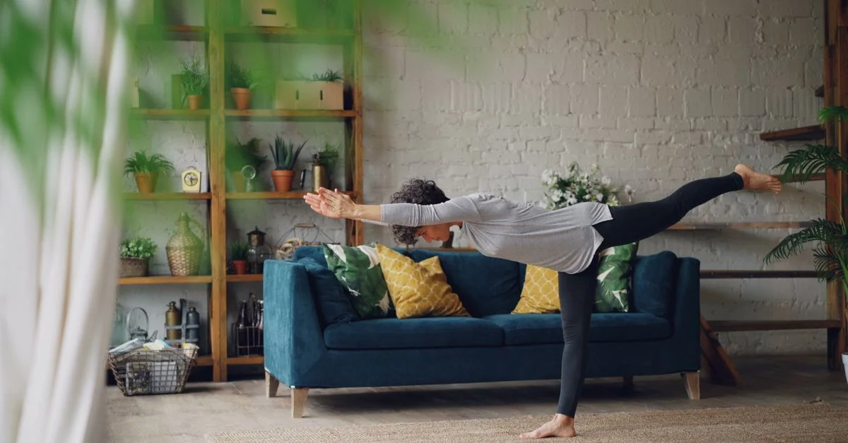 Femme pratiquant le yoga dans un salon confortable et élégant.