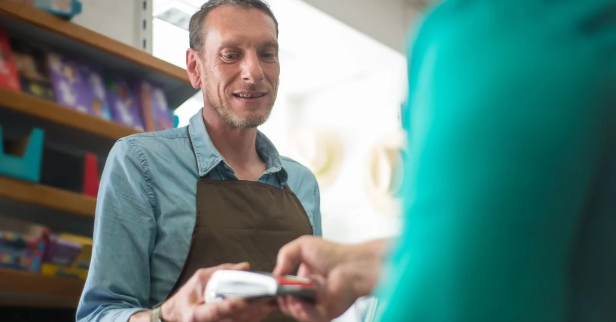 Un employé de magasin assistante un client avec une transaction de paiement dans un cadre de boutique.
